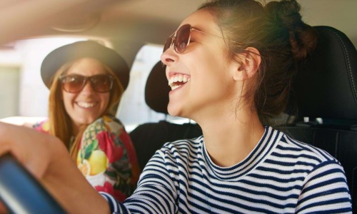 a woman in a car with a woman in the back seat