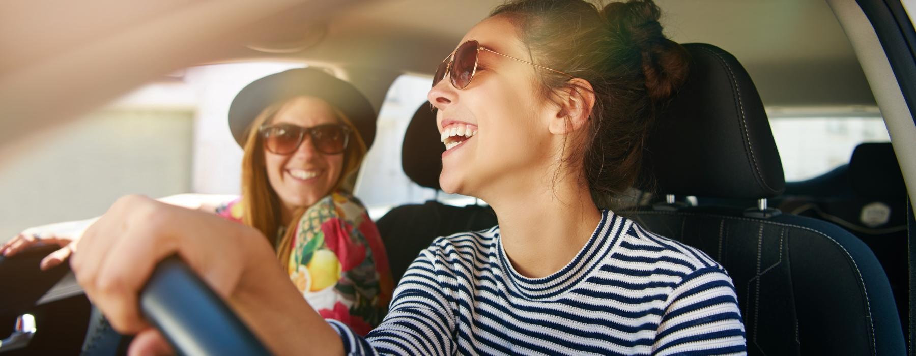 a woman in a car with a woman in the back seat