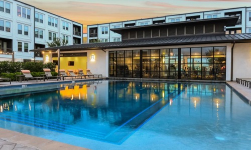 a pool in a courtyard with buildings in the background
