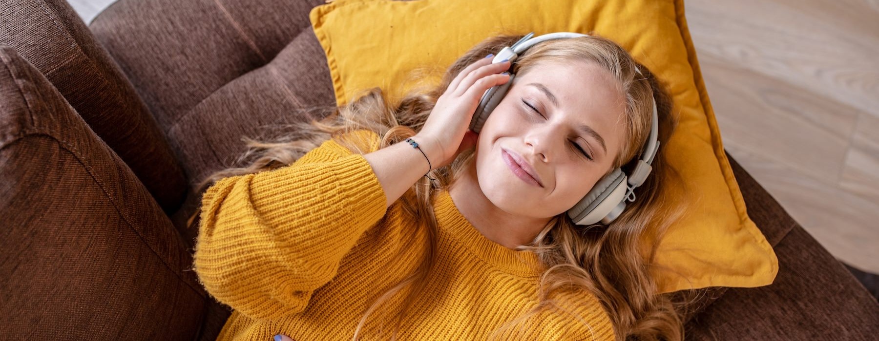 a person listening to headphones on a couch